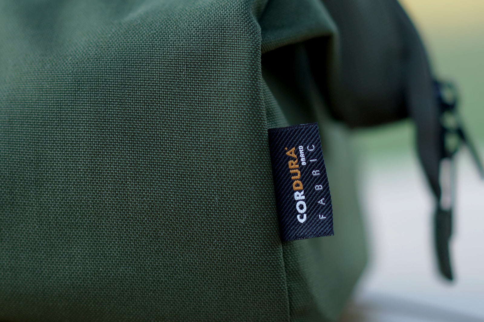 Zoomed in shot of army green Mogu outdoors toolbag with Codura fabric tag