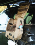 A caddy bag opened up and hanging vertically from the side of a car, with pockets and pouches open for easy access to cooking gear and utensils