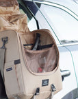 Camp kitchen caddy hanging on side of car, open with a wide compartment for cooking gear and pouches for utensils and herbs. 